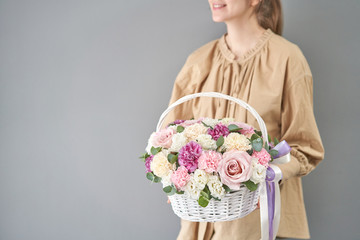 Wall Mural - Flowers delivery. Flower arrangement in Wicker basket. Beautiful bouquet of mixed flowers in woman hand. Floral shop concept . Handsome fresh bouquet.