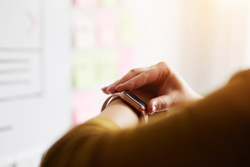 Wall Mural - close up of woman using smartwatch while working in office