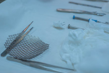 Close-up Of A Sterile Operating Table With Medical Neurosurgical Instruments, Including A Titanium Plate, A Mesh For The Skull, Medical Screwdrivers With Screws.