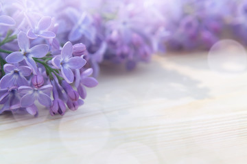 Wall Mural - Beautiful floral blank for design - a border of lilac flowers on a wooden table with copy space for text