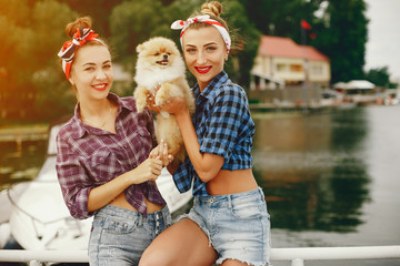 Elegant pin up ladies in a shirt in a cell. Girl with cute little dog. Women standing near water