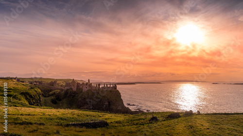 Ruined medieval Dunluce Castle on the cliff at amazing sunset, Wild Atlantic Way, Bushmills, County Antrim, Northern Ireland Tableau sur Toile