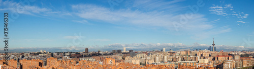 Fotomural Skyline of the city of Madrid, on a day with blue sky and clouds, from the popul