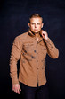 © zamuruev - man in a brown shirt on a black background.