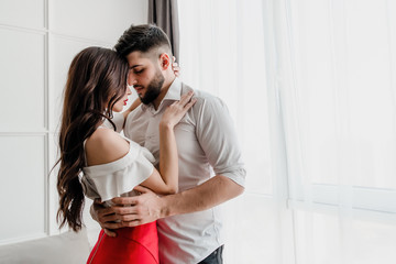 boyfriend kisses girlfriend at home in apartment