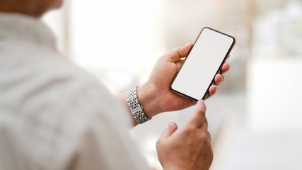 Cropped shot of  texting  blank screen smartphone with blurred office room