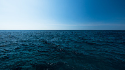 Wall Mural - Dark and blue open sea with blue sky