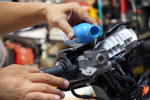 Mechanic Check And Add Brake Fluid On Motorcycle Brake Reservoir In Garage, Motorcycle Maintenance And Service And Repair Concept