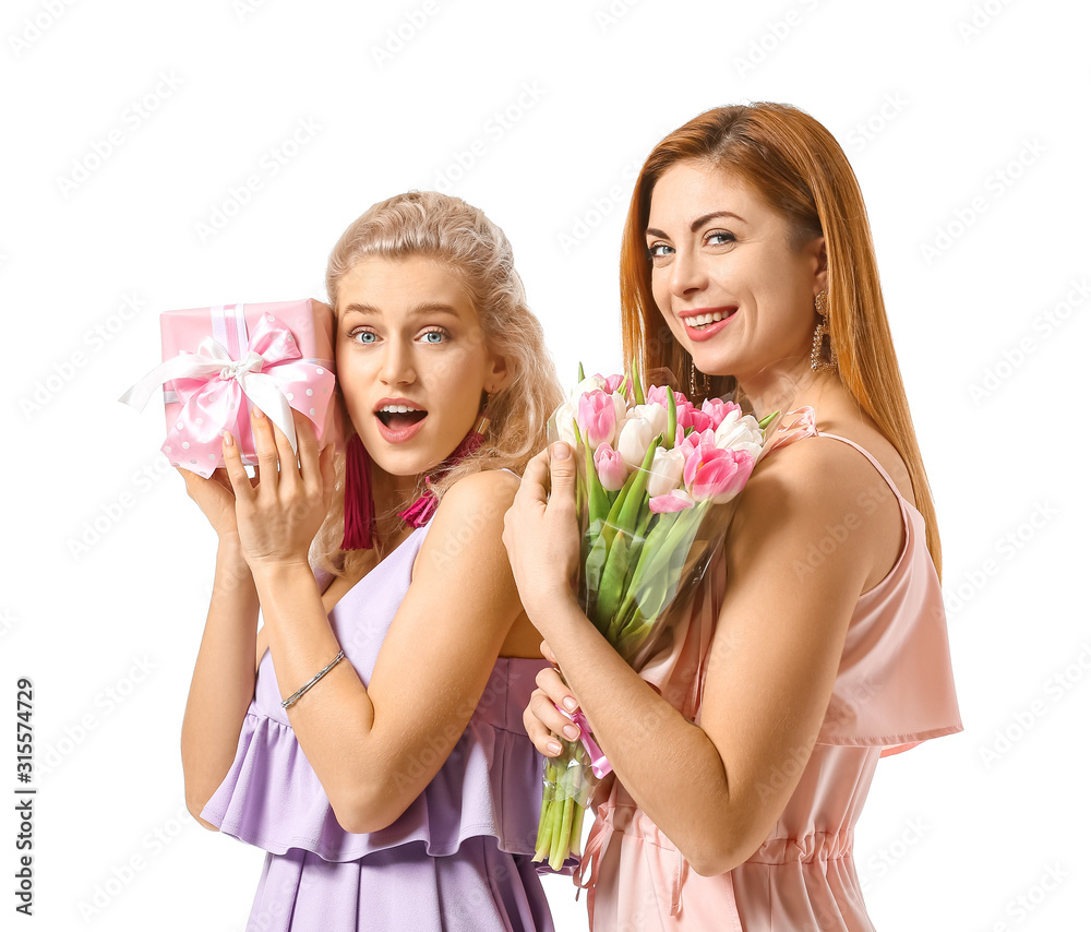 Beautiful young women with gifts on white background. International Women's Day celebration