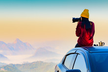 Woman Traveller Photographer Sitting To Takes A Photo Shot On Her Owns Roof Of The Car With Scenery View Of The Mountain And Mist Morning In Background