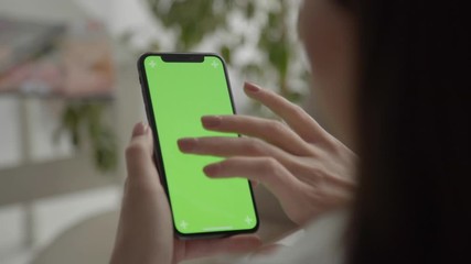 POV. Woman using app, viewing green screen on phone