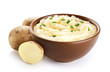 © vitals - Bowl with mashed potatoes and raw potatoes isolated on white background.