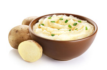 Bowl With Mashed Potatoes And Raw Potatoes Isolated On White Background.