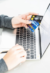 Close up of female hands holding credit card making online payment