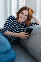 Wall Mural - Happy relaxed young woman grinning at the camera