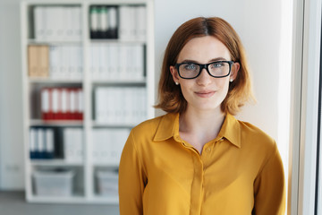 Wall Mural - Smiling young businesswoman wearing glasses