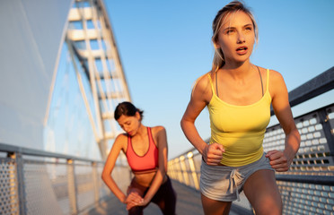 Wall Mural - Beautiful women working out in a city. Running, jogging, exercise, people, sport concept