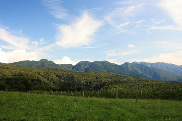 White clouds over green hills