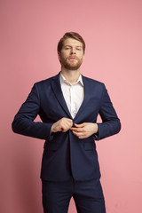 Wall Mural - portrait of young confident caucasian man isolated on coral background. valentine's day celebration.