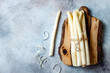 Bunch of raw white asparagus served on wooden board. Top view, copy space