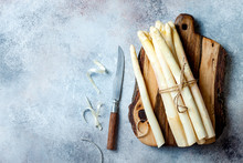 Bunch Of Raw White Asparagus Served On Wooden Board With Knife. Top View, Copy Space