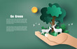 © Sunset Paper's - Paper art style of hand holding tree and plants with deers, save the planet and energy concept.