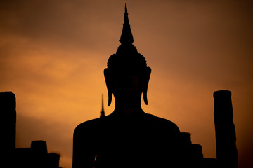 Silhouette of  Buddha image at Wat Mahathat in Sukhothai Historical Park, Thailand. Buddha statue used as amulets of Buddhism religion. Sukhothai Historic Park