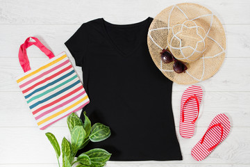 T shirt black and slippers. T-shirt Mockup flat lay with summer accessories. Hat, bag, red flip flops and sunglasses on wooden floor background. Copy space. Template blank canvas. Front top view.