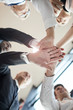 © AnnaStills - Low angle view of business team holding hands and support each other before meeting at office