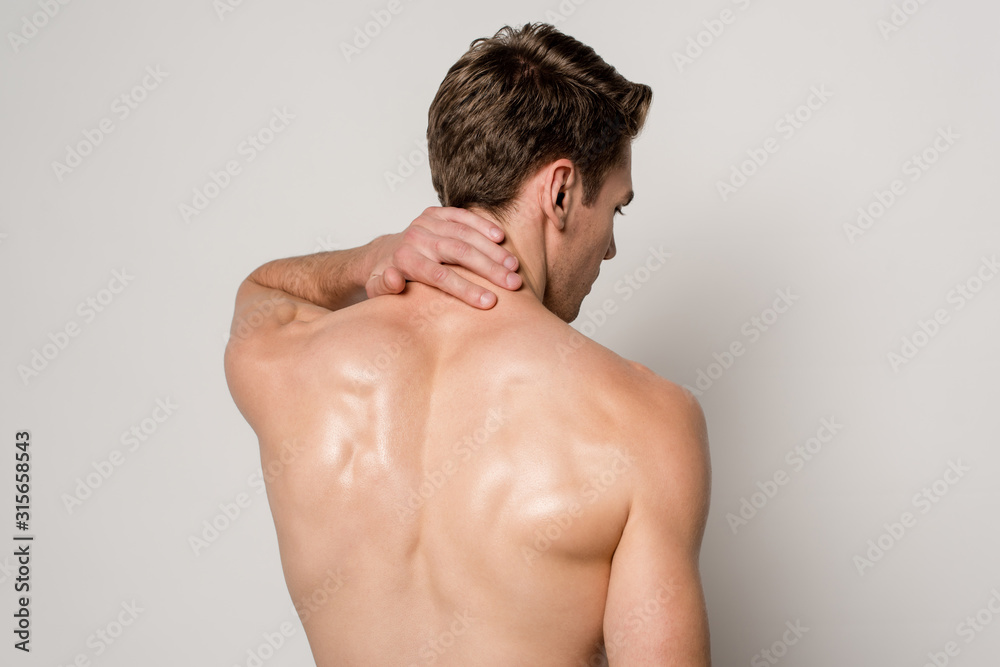 back view of man having neck pain isolated on grey - obrazy, fototapety, plakaty 