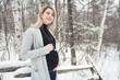 © Louis-Photo - Young happy pregnant woman in snowy forest
