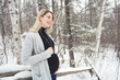 © Louis-Photo - Young happy pregnant woman in snowy forest