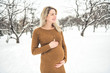© Louis-Photo - Young happy pregnant woman in snowy forest