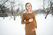 © Louis-Photo - Young happy pregnant woman in snowy forest