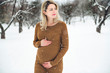 © Louis-Photo - Young happy pregnant woman in snowy forest