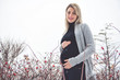 © Louis-Photo - Young happy pregnant woman in snowy forest