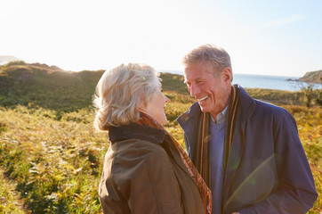 Wall Mural - Loving Active Senior Couple Walking Along Coastal Path In Autumn Together