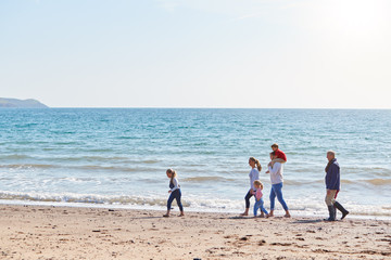 Wall Mural - Multi-Generation Family Walking Along Shoreline Of Beach By Waves Together