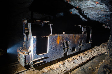 Underground gold mine shaft tunnel drift with old electric locomotive