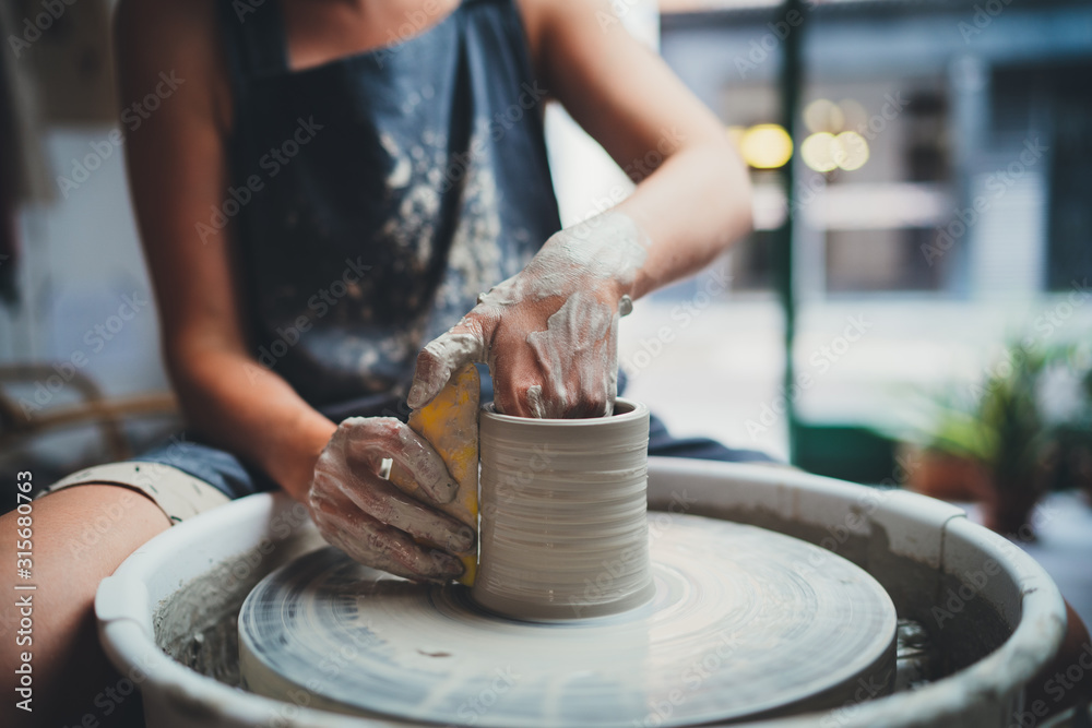 Cropped Image of Unrecognizable Female Ceramics Maker working with Pottery Wheel in Cozy Workshop Makes a Future Vase or Mug, Creative People Handcraft Pottery Class  - obrazy, fototapety, plakaty 