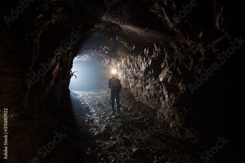 Fotografía Underground gold mine shaft tunnel drift with miner and light
