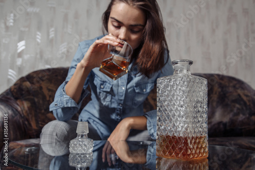 Cuadros en Lienzo Young female drinks alcoholic beverage in depression and stress