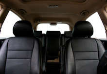 The car interior was photographed from the dashboard. The photo shows the front seats, rear seats and beige ceiling.