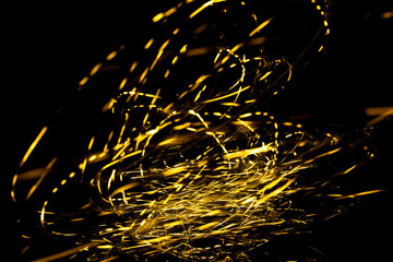 Wall Mural - abstract texture of Golden sparkles on a black background, Golden highlights in the form of spirals and iridescence