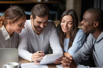 Happy international students gather in cafe studying together