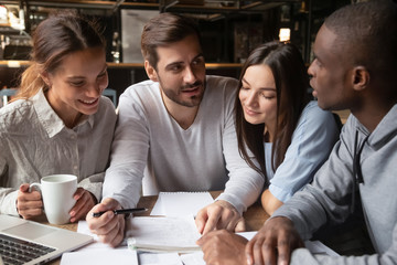 Multiracial young people studying in coffeehouse together