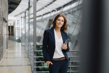 Confident Businesswoman Holding A Tablet In A Modern Office Building
