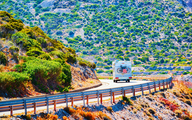 Sticker - Camper with bicycle on road at Buggerru in Carbonia-Iglesias in Sardinia Island, Italy summer. Caravan motorhome on holidays at highway. Minivan rv on motorway. Cagliari province. Mixed media.