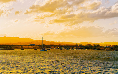 Wall Mural - Sunset or sunrise at Harbor at Mediterranean Sea in Old city of Olbia on Sardinia Island in Italy. Italian coast of Sardegna. Sky with romantic clouds. Mixed media.