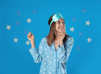 Sticker - Beautiful woman wearing pajamas and sleep mask on light blue background. Bedtime